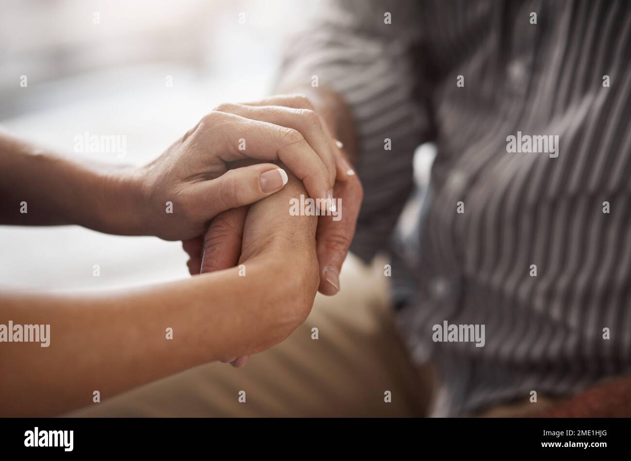 Manchmal braucht man nur etwas Unterstützung. Zwei unerkannte Menschen, die bequem Händchen halten. Stockfoto