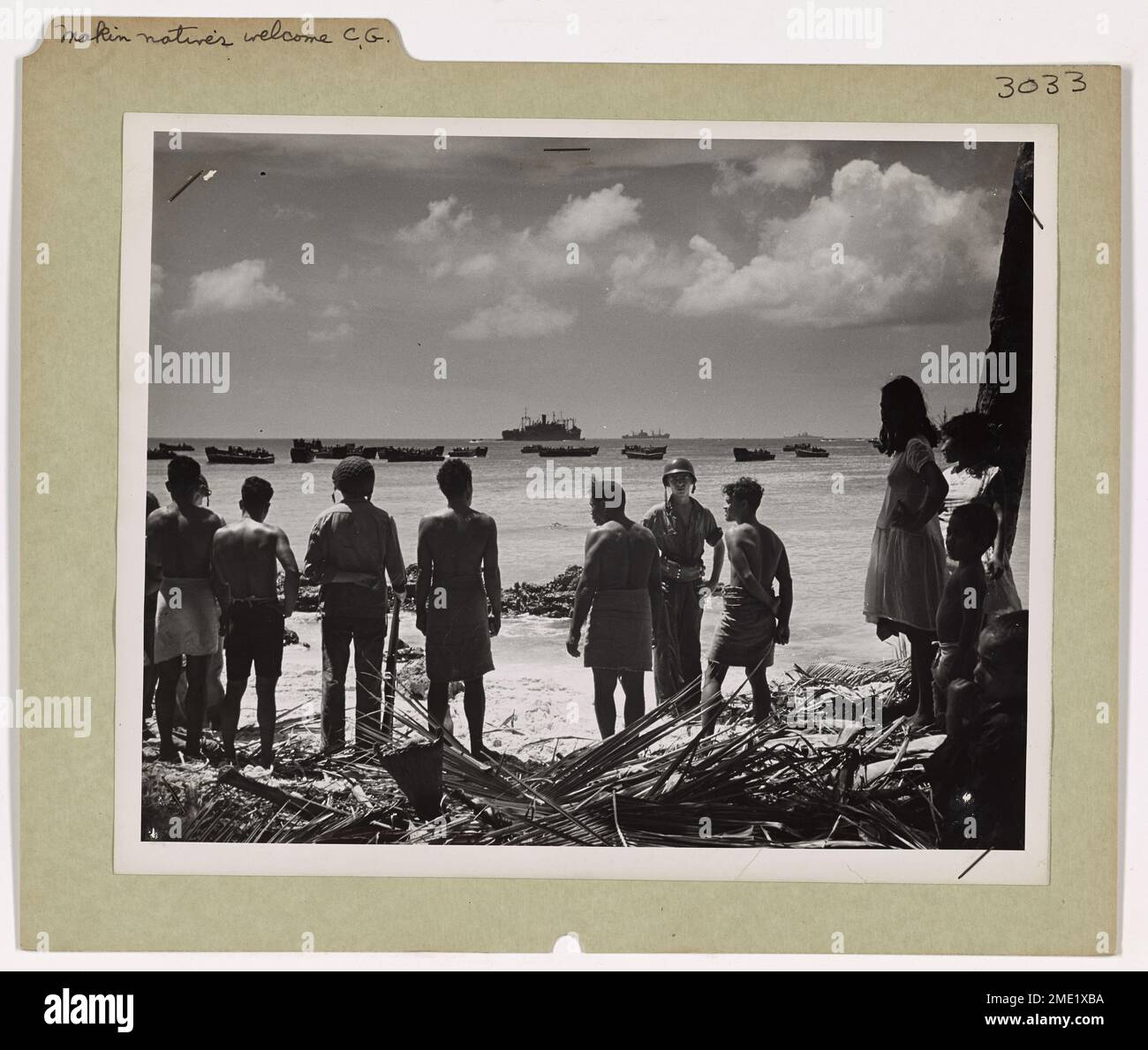 Die Eingeborenen von Makin Island, im Pazifik, begrüßen US-Küstenwache und Navy-Einsatzkräfte, die während des Zweiten Weltkriegs ankommen. Fasziniert von der Ankunft amerikanischer Kriegsschiffe und Landungsboote begrüßen die Eingeborenen die amerikanischen Streitkräfte als Teil des größeren Pazifikfeldzugs. Stockfoto