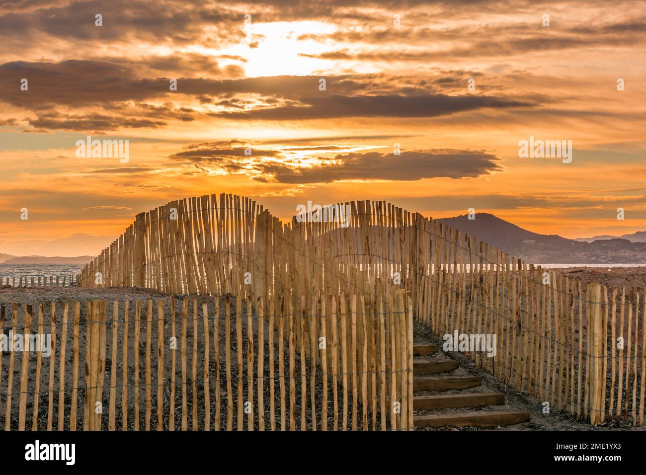 Panoramablick auf den Holzzaun am Strand vor dem dramatischen Sonnenuntergang in Saint Tropez, Südfrankreich Stockfoto