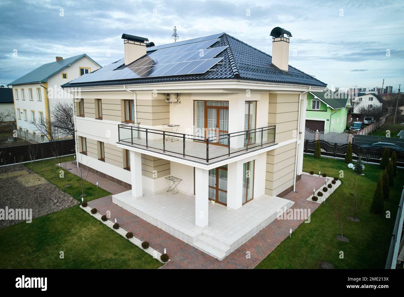 Wohnsitz mit Solarpaneelsystem zur Stromerzeugung durch Photovoltaik. Neues zweistöckiges Haus mit Solarmodulen auf dem Dach. Konzept ökologischer erneuerbarer Energiequellen. Stockfoto