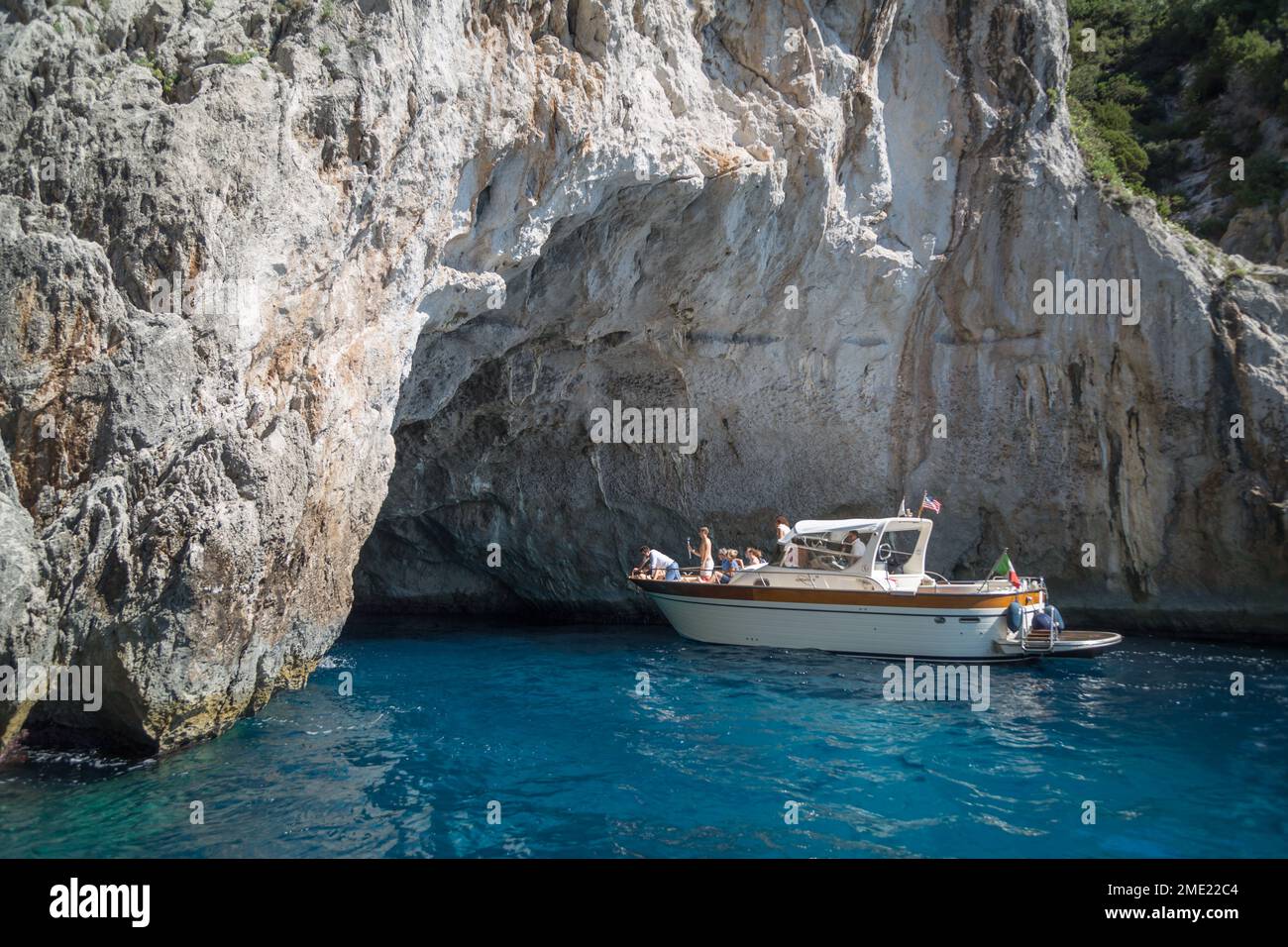 Menschen in Booten erkunden die Höhlen rund um die Insel Capri, im Tyrrhenischen Meer, Kampanien, Italien. Stockfoto