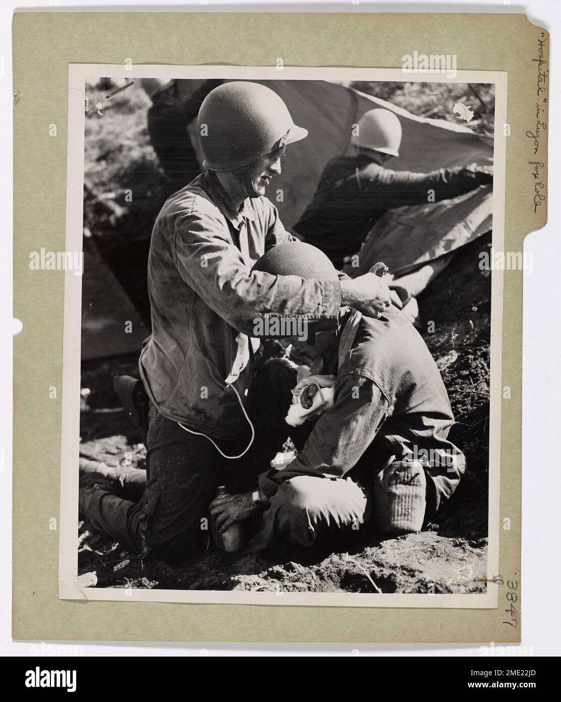 "Krankenhaus" in einem Luzon Foxhole. "Krankenhaus" in einem Luzon Foxhole. Mitglied einer Strandparty der Küstenwache kleidet den zerschmetterten Arm eines verwundeten Yankee, während die erste Welle am 9. Januar am Lingayen Gulf, Luzon, den Strand erreicht. Medizinische Notfallstationen wurden in Schützenlöchern als Schutz vor Japsenfeuer eingerichtet. Der Küstenwächter ist Leland Lena, Spitallehrling zweiter Klasse, aus Berkeley, Kalifornien Stockfoto