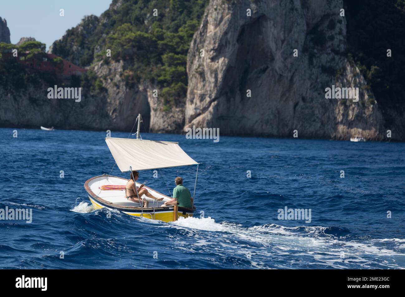 Ein Paar (Mann und Frau), das um die Insel Capri, im Tyrrhenischen Meer, Kampanien, Italien fährt. Stockfoto