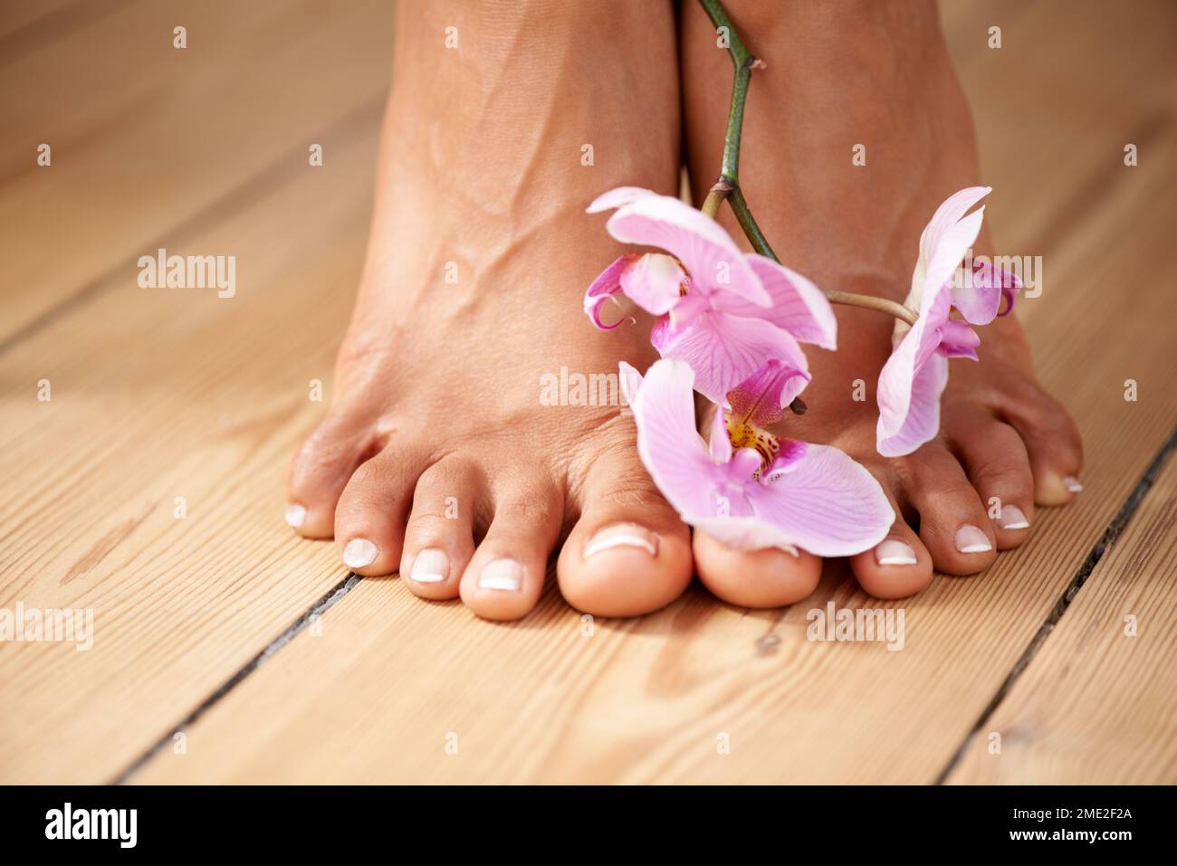 Pediküre, Blumen und Füße der Frau für Spa, Schönheit und Wellness mit Luxus, Naturkosmetik und Blumen. Blume, Fußpflege und Modellnägel Stockfoto