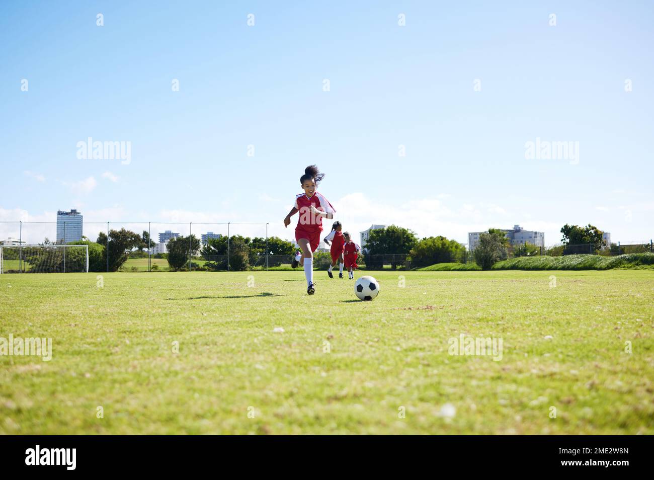 Fußball, Training oder Kinder und eine Mädchenmannschaft, die zusammen auf einem Spielfeld trainieren. Fitness, Fußball und Gras mit Kindern beim Laufen oder Stockfoto