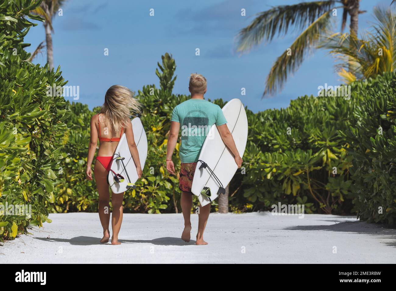 Paar mit Surfbrettern, die zum Strand laufen Stockfoto
