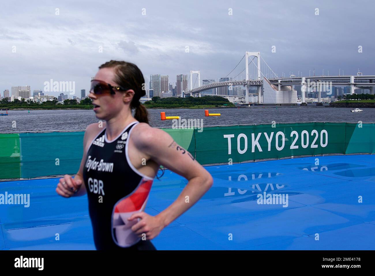Georgia Taylor-Brown, of Great Britain, runs past the landmark "Rainbow Bridge" while competing during the women's individual triathlon at the 2020 Summer Olympics, Tuesday, July 27, 2021, in Tokyo. (AP Photo/David Goldman) Stockfoto