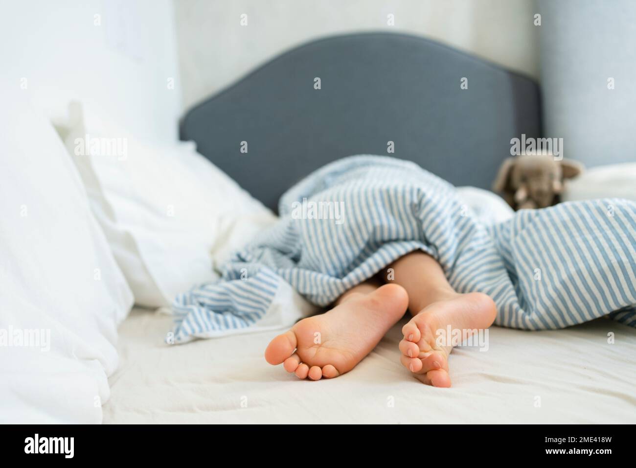 Beine eines Mädchens, das zu Hause im Bett liegt Stockfoto