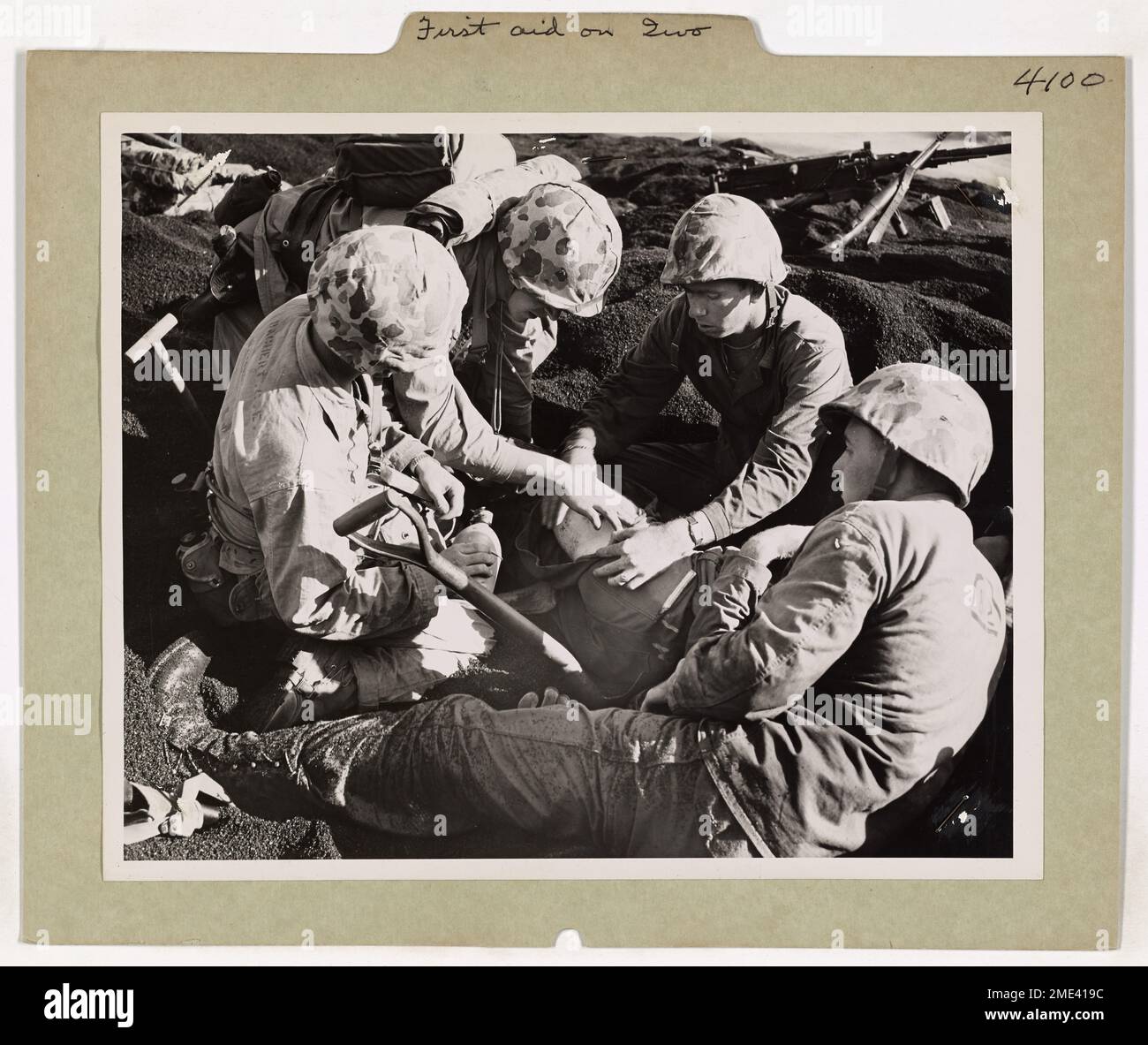 Erste Hilfe Auf Iwo Jima. Dieses Bild zeigt einen verwundeten Marine, der von Sanitätern im „Kaffeesand“ auf Iwo Jima kurz nach der ersten Welle an Land behandelt wird. Stockfoto