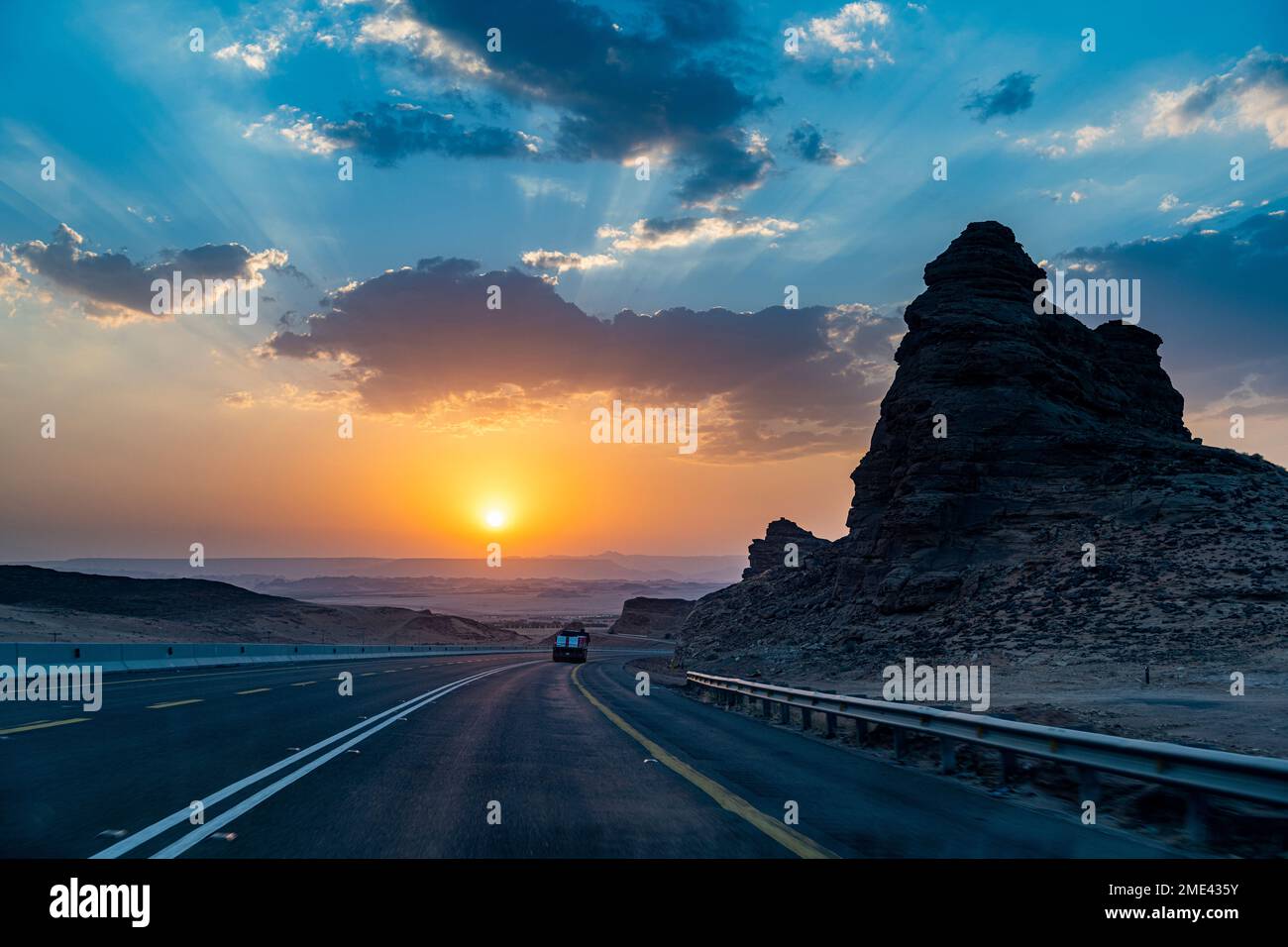 Saudi-Arabien, Al-Ula, Sonnenuntergang über abgelegenem Highway Stockfoto
