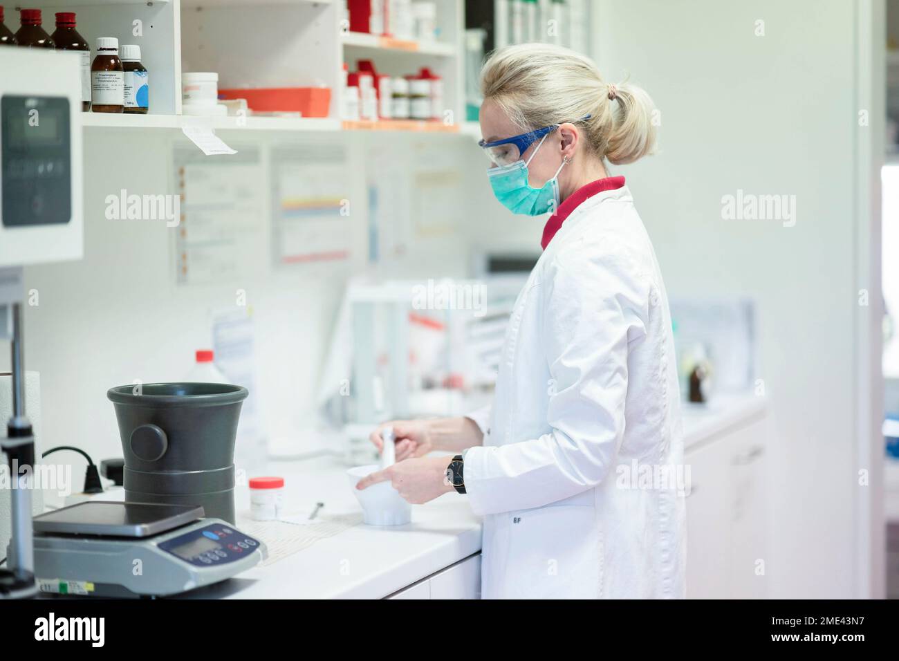 Wissenschaftler tragen Gesichtsschutzmaske Herstellung von Medizin im Labor Stockfoto