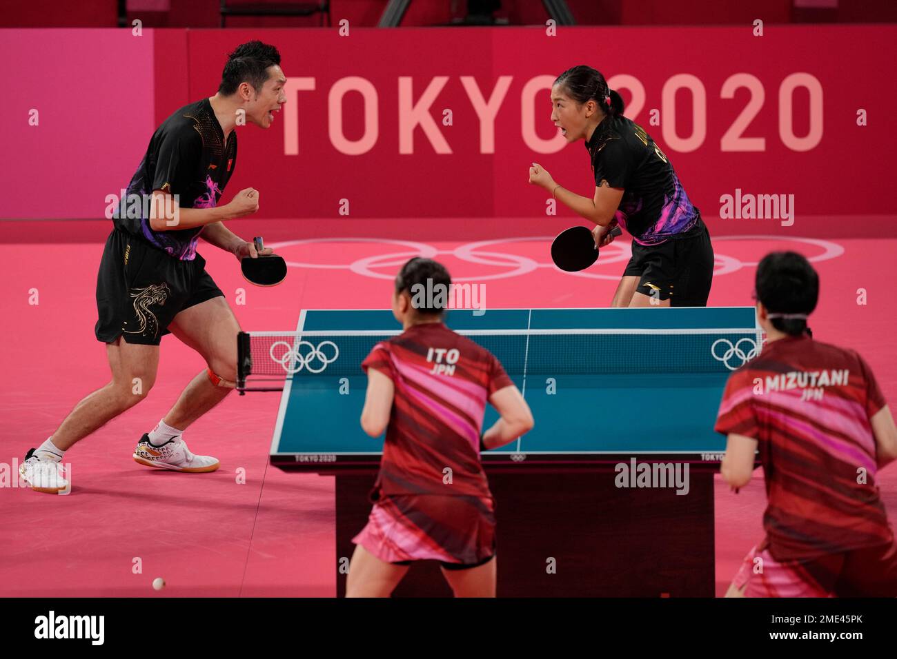 China's Xu Xin, left, and Liu Shiwen react during the table tennis mixed doubles gold medal match against Japan's Mima Ito and Jun Mizutani at the 2020 Summer Olympics, Monday, July 26, 2021, in Tokyo. (AP Photo/Kin Cheung) Stockfoto