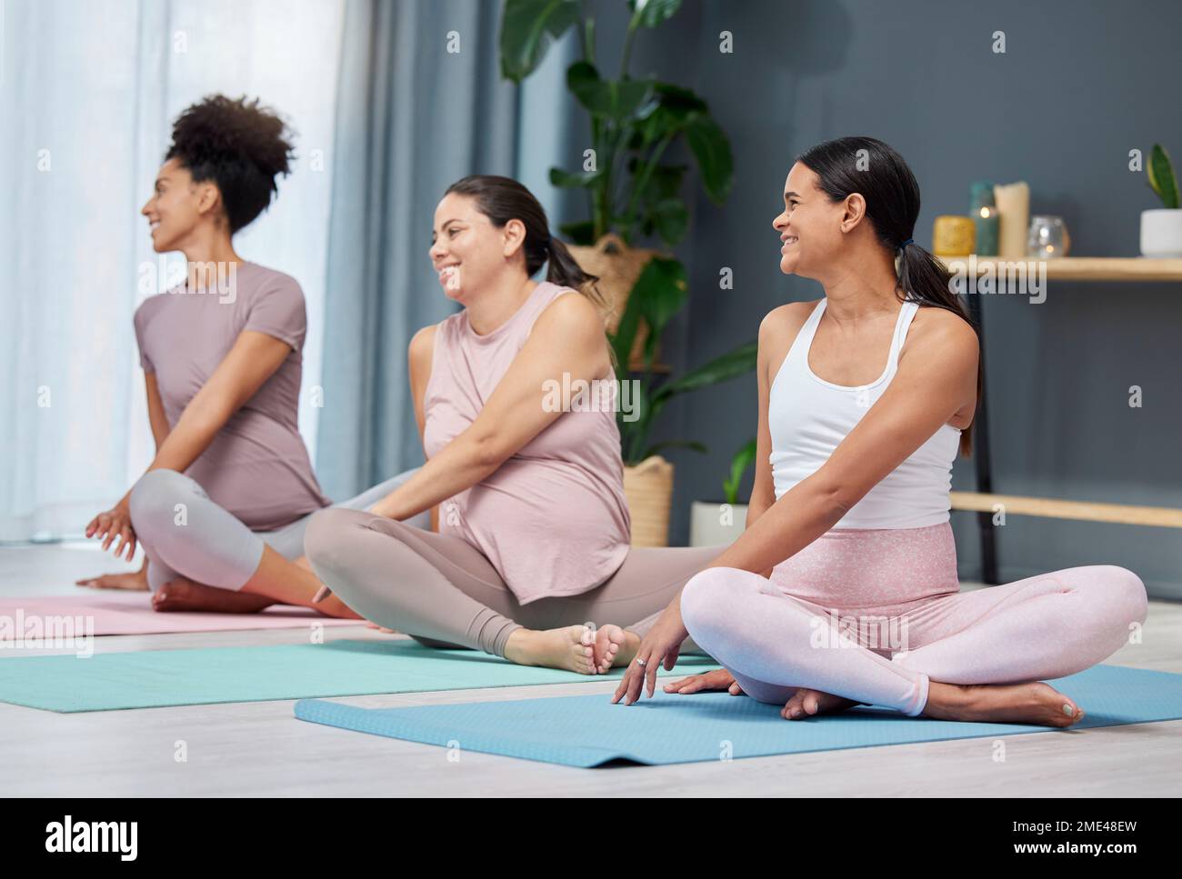 Schwangere Yoga, dehnen und entspannen Sie sich auf einer Etage für Bewegung, Fitness und Wellness in einem gemeinsamen Zuhause. Freunde, Schwangerschaft und Gruppendehnung, Workout Stockfoto