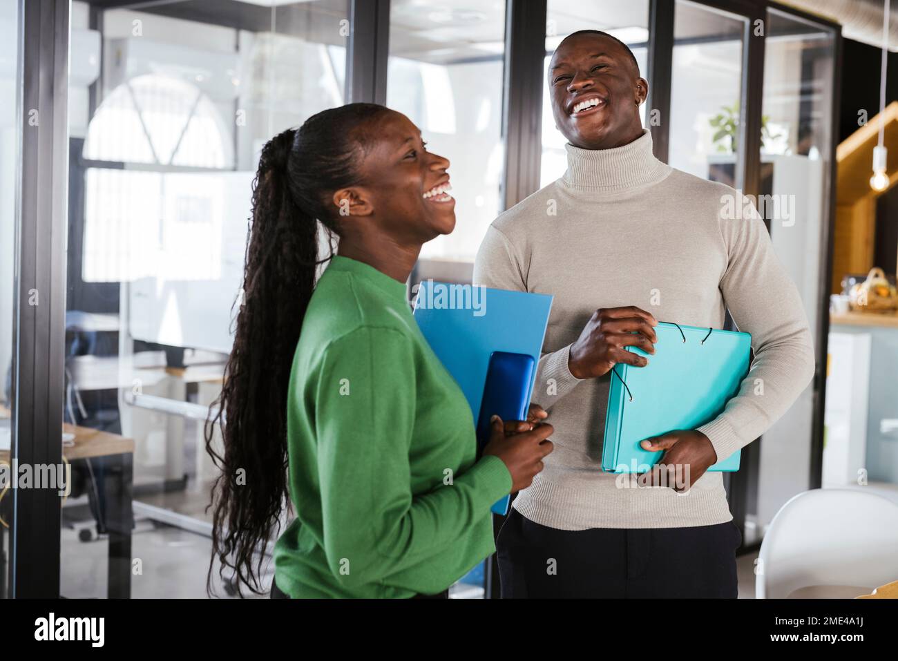 Fröhlicher Geschäftsmann, der mit einem Kollegen im Büro lacht Stockfoto