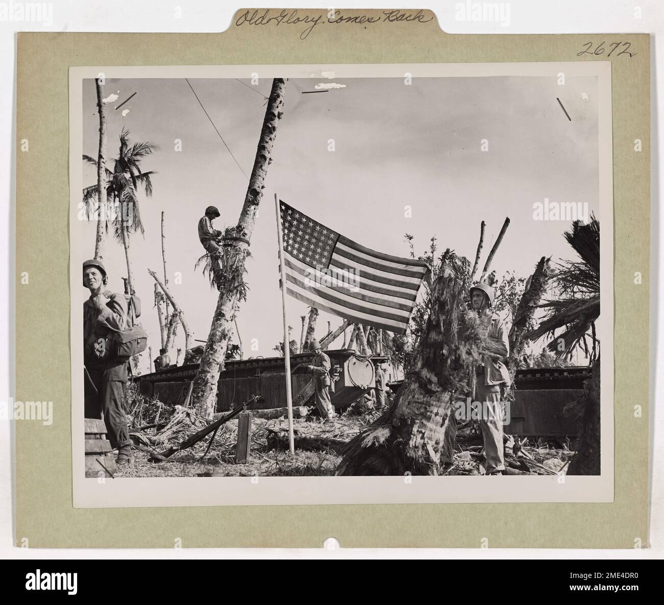 Die US-Küstenwache und die US-Navy erheben die Sterne und Streifen über Guams Stränden nach ihrer Befreiung und markieren die Rückkehr der amerikanischen Souveränität während des Zweiten Weltkriegs. Stockfoto