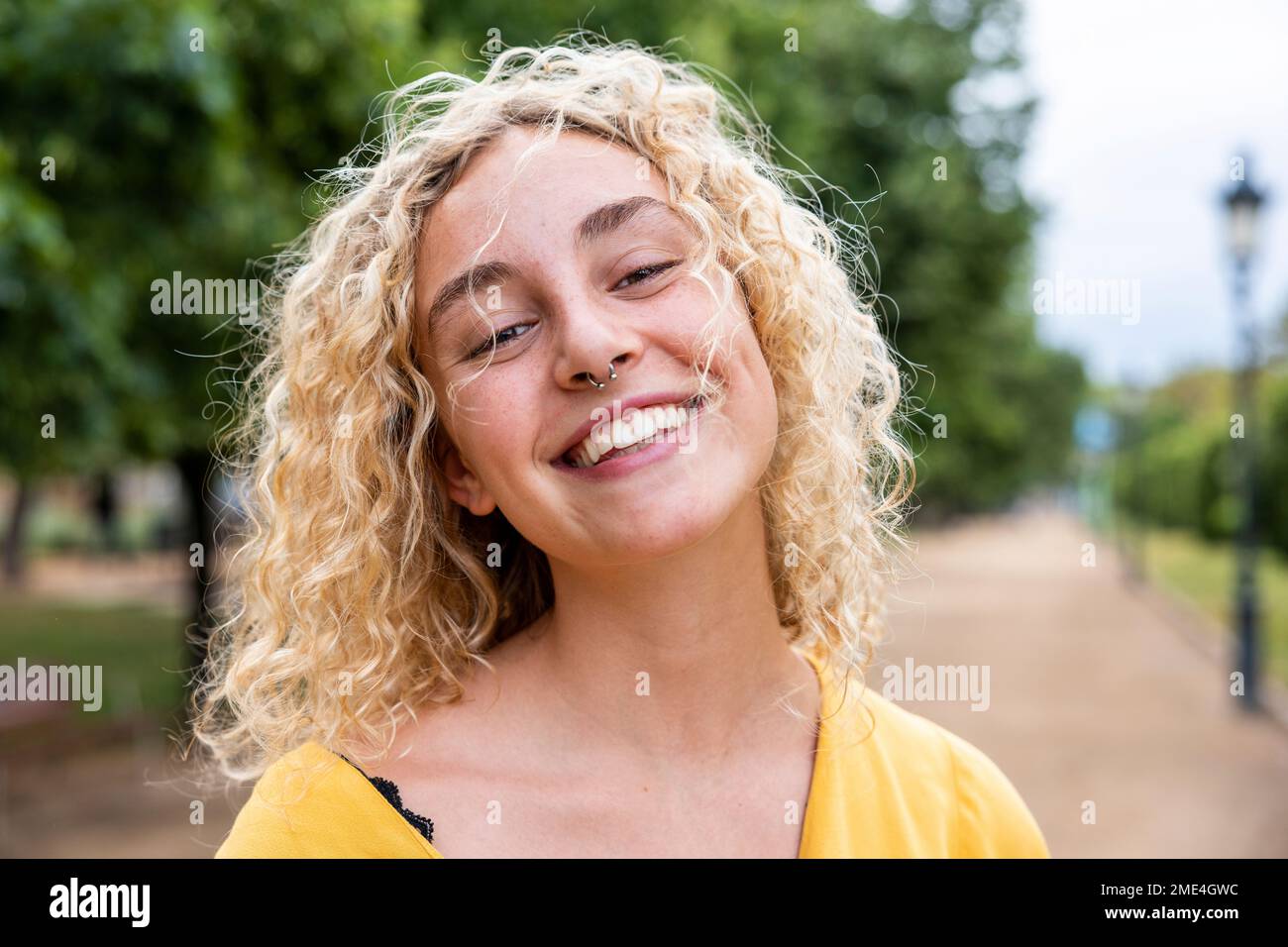 Glückliche junge Frau mit blondem Haar im Park Stockfoto
