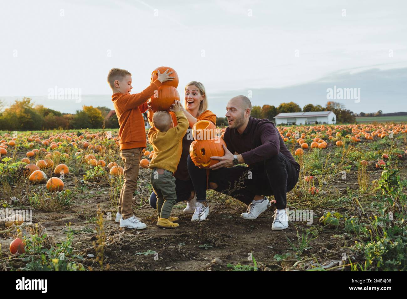 Glückliche Eltern mit Kindern, die Laternen im Feld tragen Stockfoto