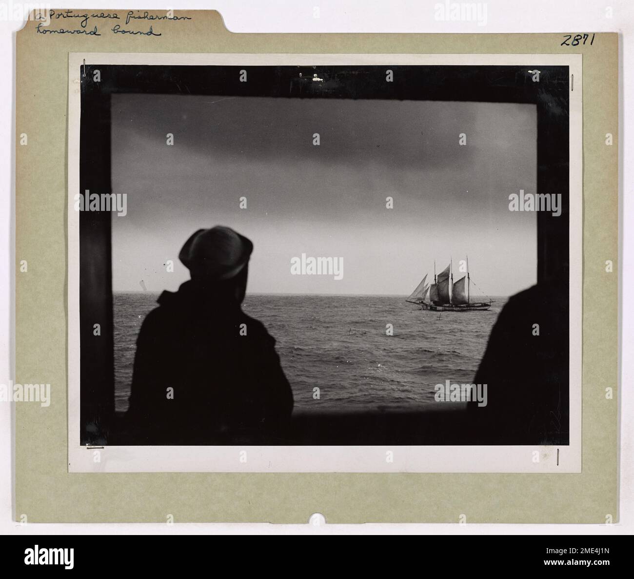 Ein portugiesischer Angler Homeward. Ein Küstenwächter, der an Bord seines Schneiders im Atlantik steht, bewundert ein Bild von Frieden und Schönheit, während ein portugiesischer Fischschoner auf seinem Heimkurs ruhig segelt. Selbst in den gefährlichen Gewässern des Krieges geht der Fischer weiter, denn das ist die Art der Männer, die ihren Lebensunterhalt vom Meer aus ernähren. Stockfoto