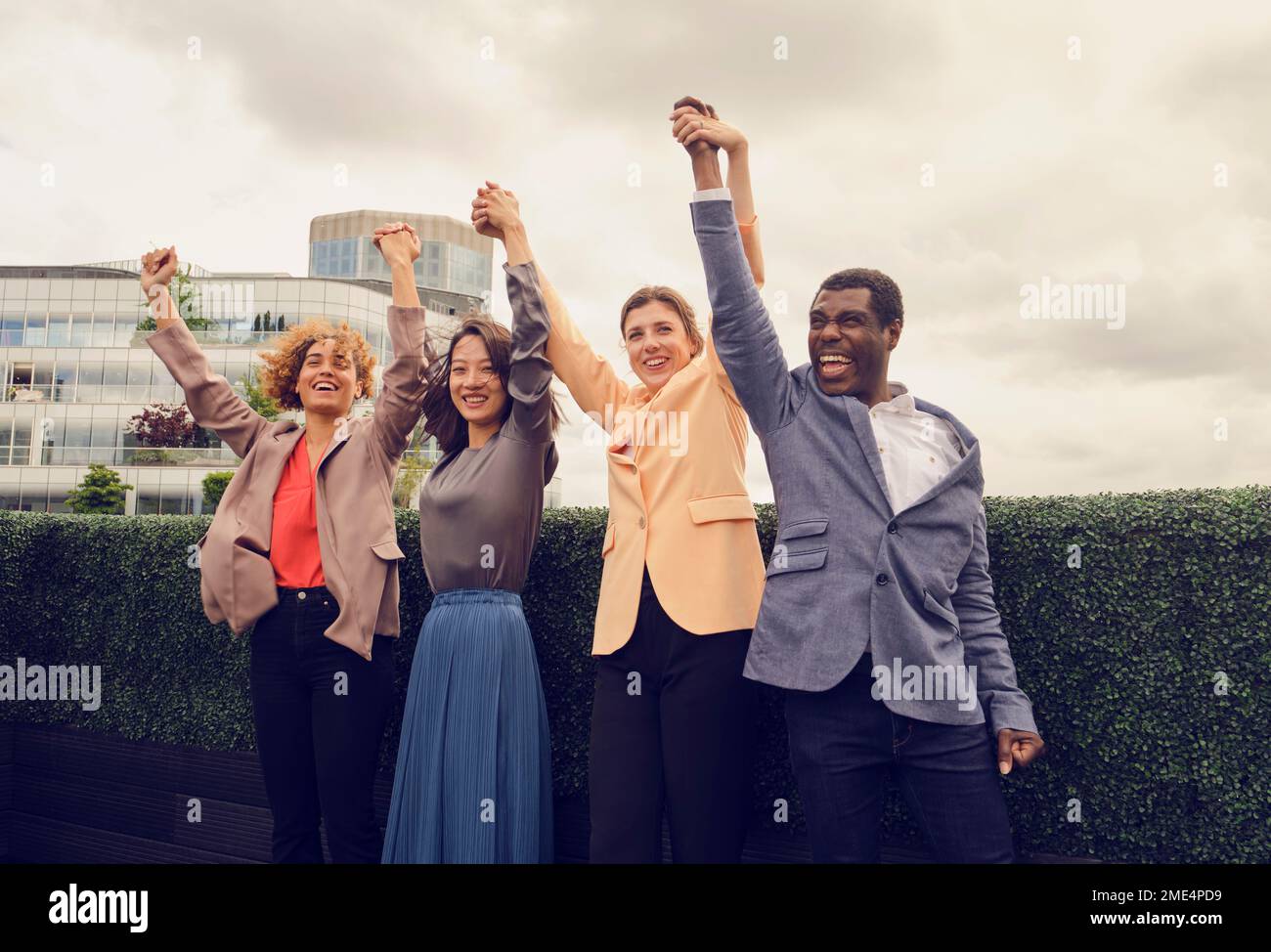 Fröhlicher Geschäftsmann mit Kollegen, die auf dem Dach feiern Stockfoto