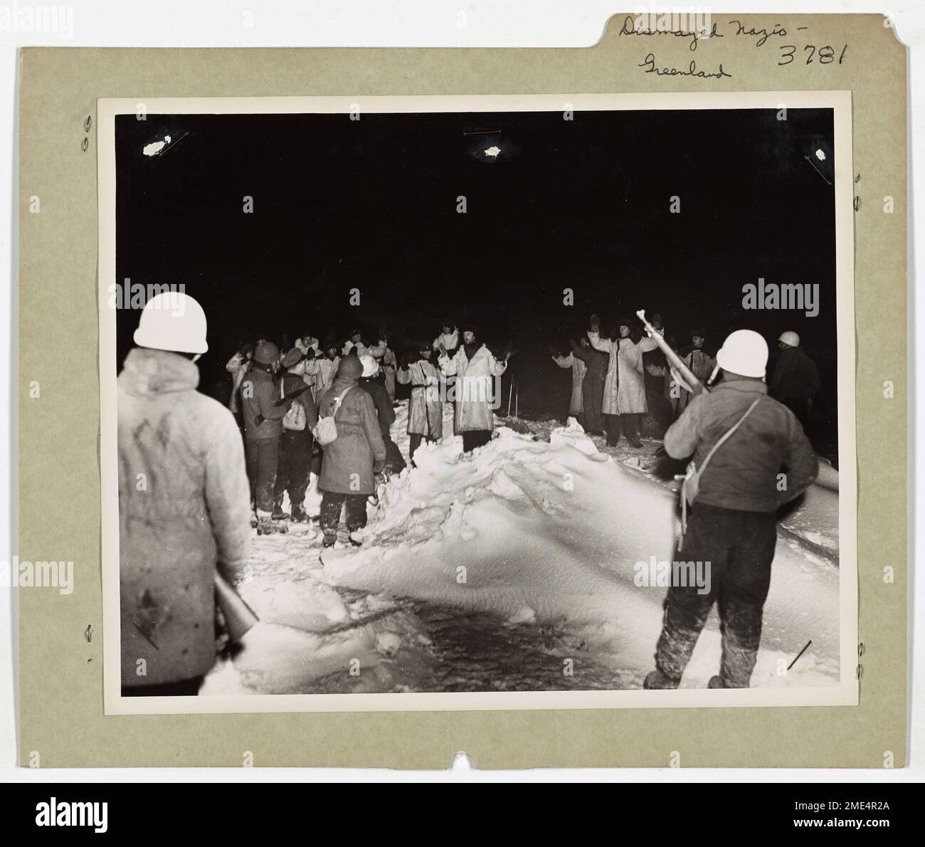 Deutsche Seeleute ergeben sich der US-Küstenwache, lassen ihren Trawler im Stich und klettern mit erhobenen Händen auf das Eis. Dies markiert das Ende ihres Fluchtversuchs während eines maritimen Konflikts. Stockfoto