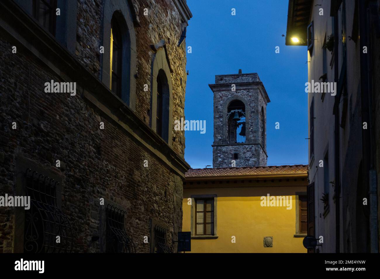 Glockenturm und Häuser in der Stadt Bibbiena in der Dämmerung Stockfoto