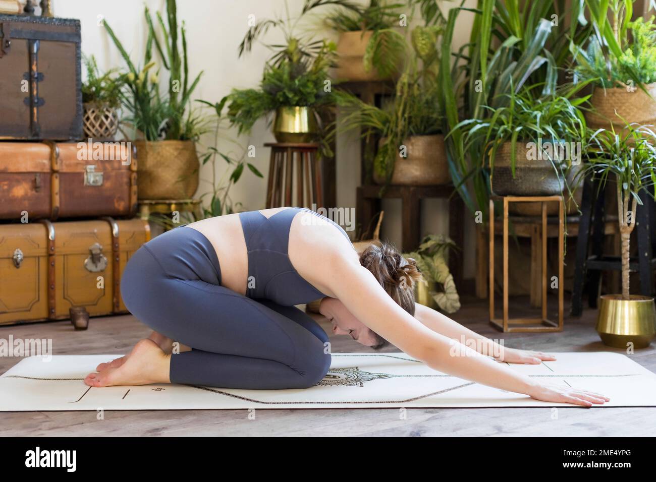 Frau, die zu Hause Yoga auf der Matte macht Stockfoto