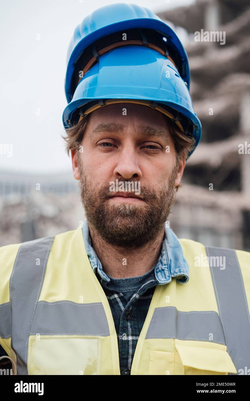 Arbeiter mit einem Haufen Schutzhelme auf dem Kopf auf der Baustelle Stockfoto