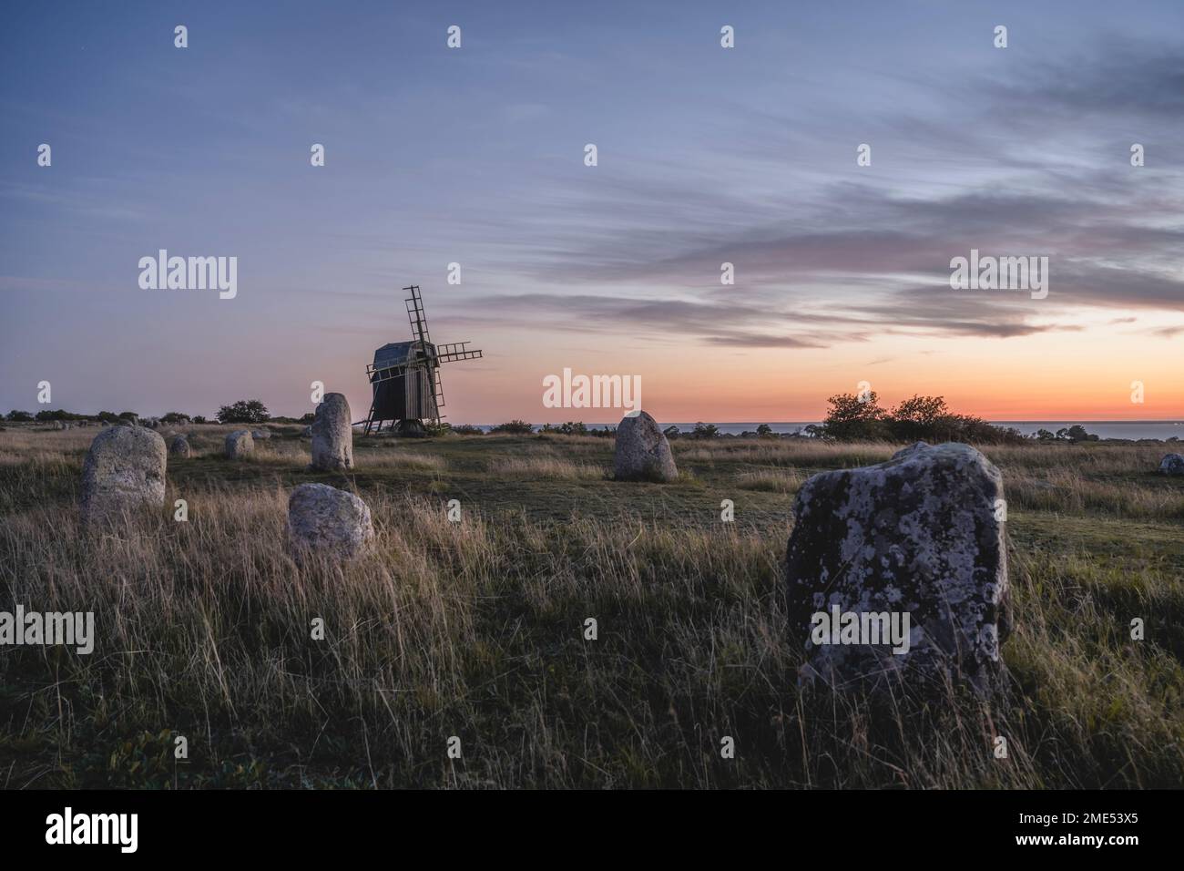 Schweden, Oland, Gettlinge, alter Grabplatz mit Windmühle im Hintergrund Stockfoto