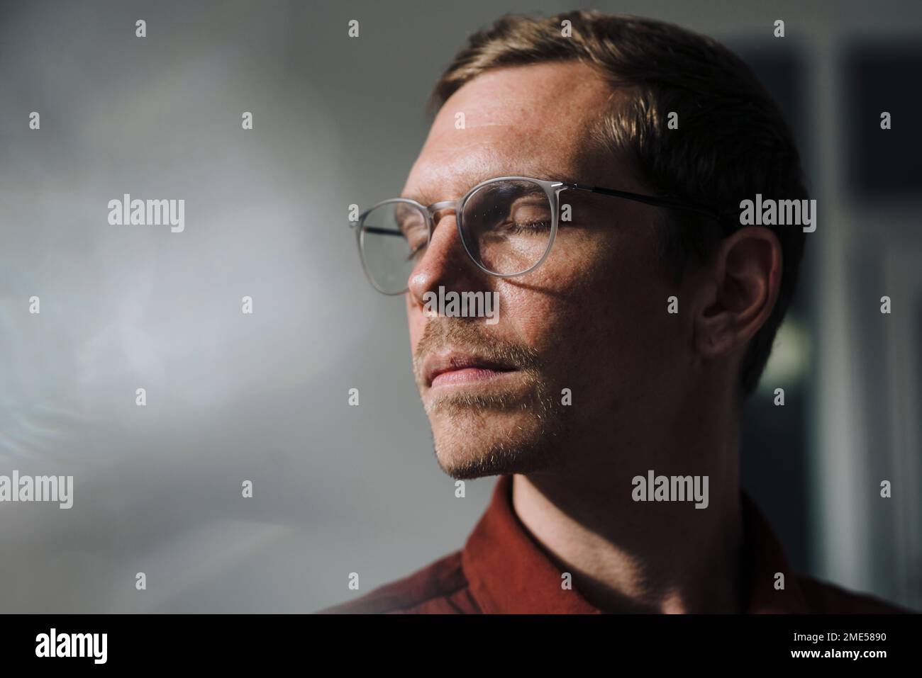 Geschäftsmann mit geschlossenen Augen im Büro Stockfoto