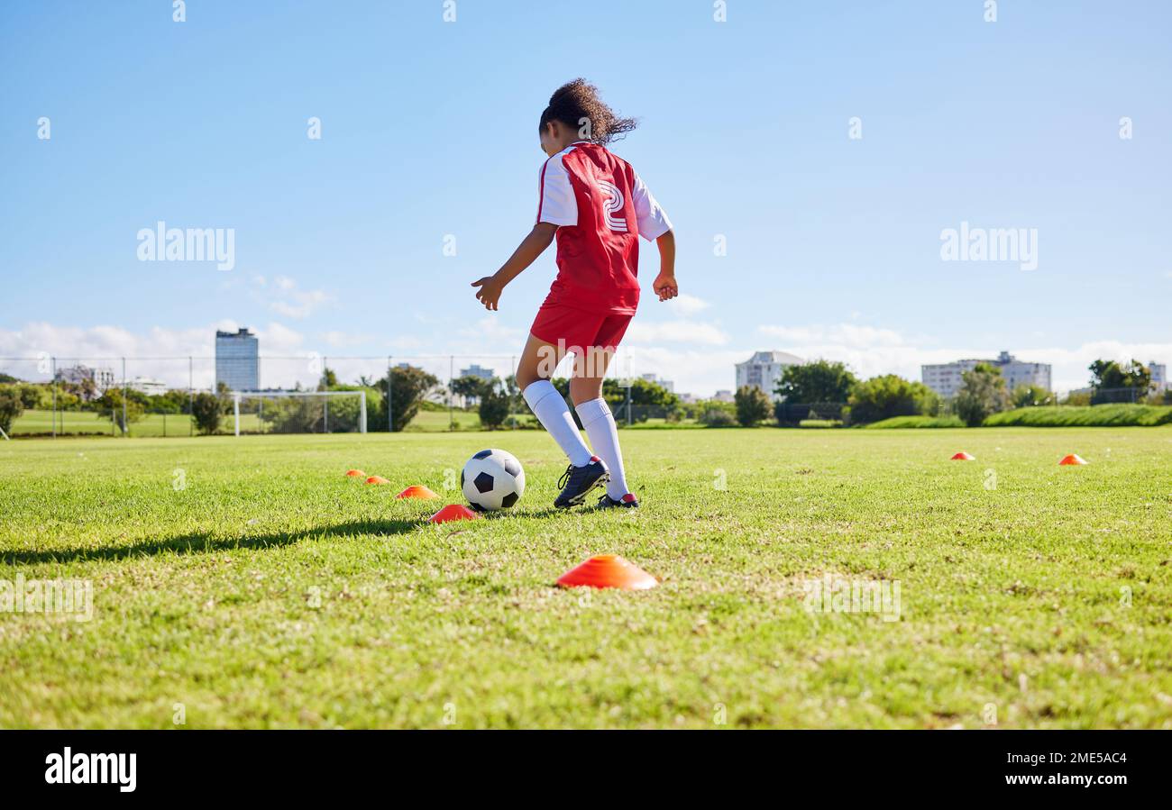 Fußballmädchen Kind, Spielfeld und Training für Fitness, Sport und Entwicklung des Gleichgewichts für Kontrolle, Geschwindigkeit und starken Körper. Weibliches Kind, schneller Fußball Stockfoto