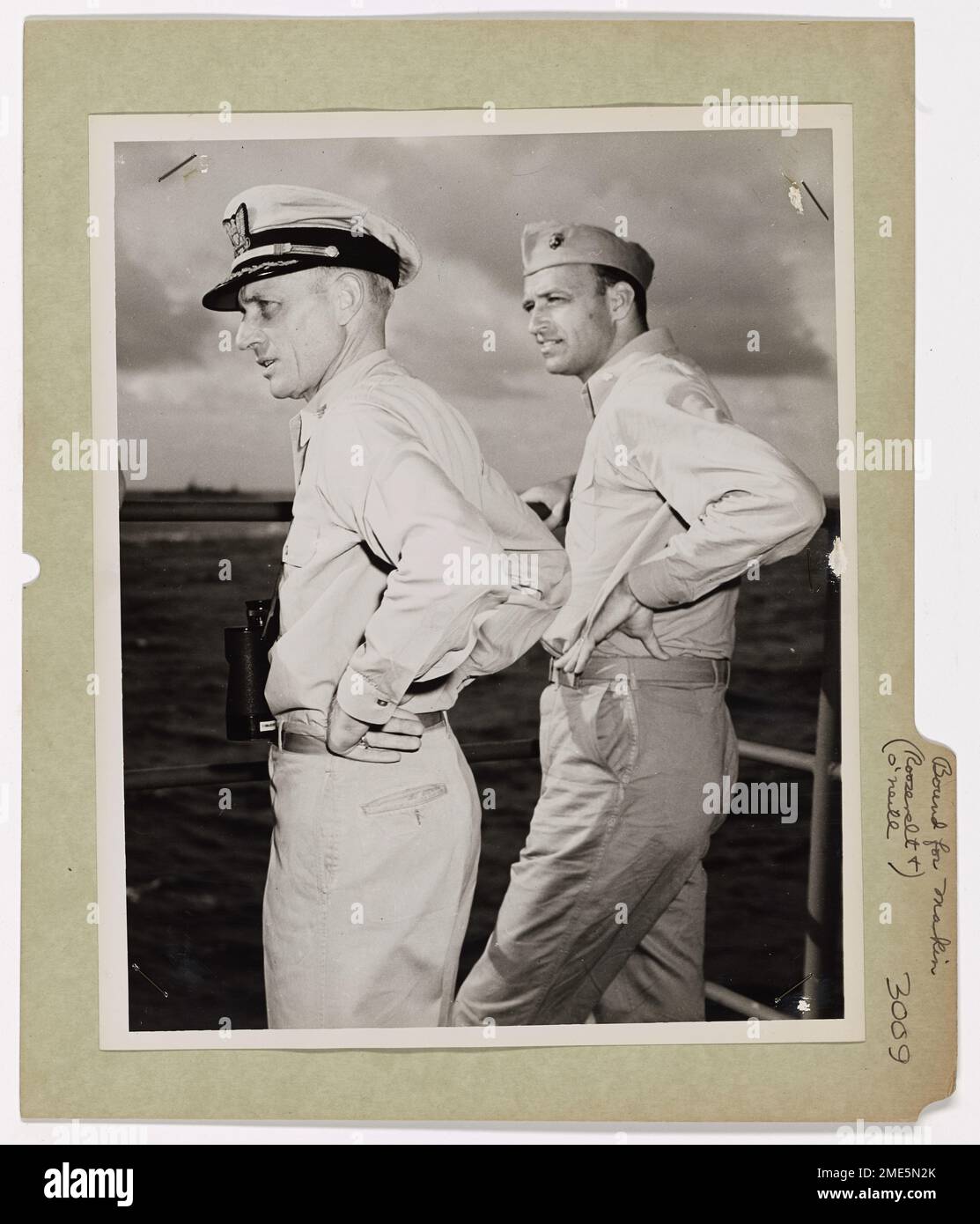Captain Merlin O'Neil von der US-Küstenwache und Lieutenant Colonel James Roosevelt von den Marines werden auf der Brücke eines bemannten Kampftransporters der Küstenwache gesehen, der als Teil der Invasionstruppe nach Makin Island fährt. Stockfoto