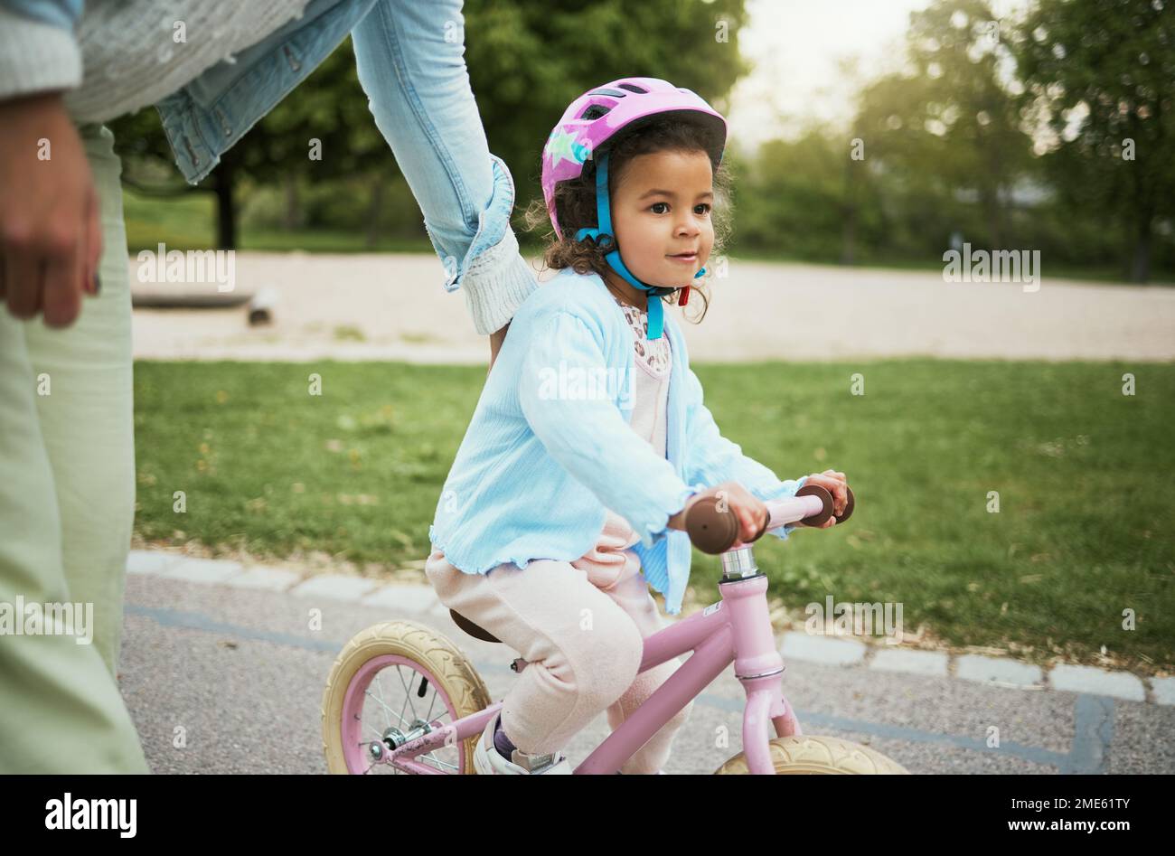 Mutter, Mädchen und lernen mit dem Fahrrad auf der Straße, auf der Straße oder auf dem Parkplatz für Liebe, Freundschaft und Freude im Urlaub. Mom, Kind und Lehrer, Radfahren und Fahrrad fahren Stockfoto