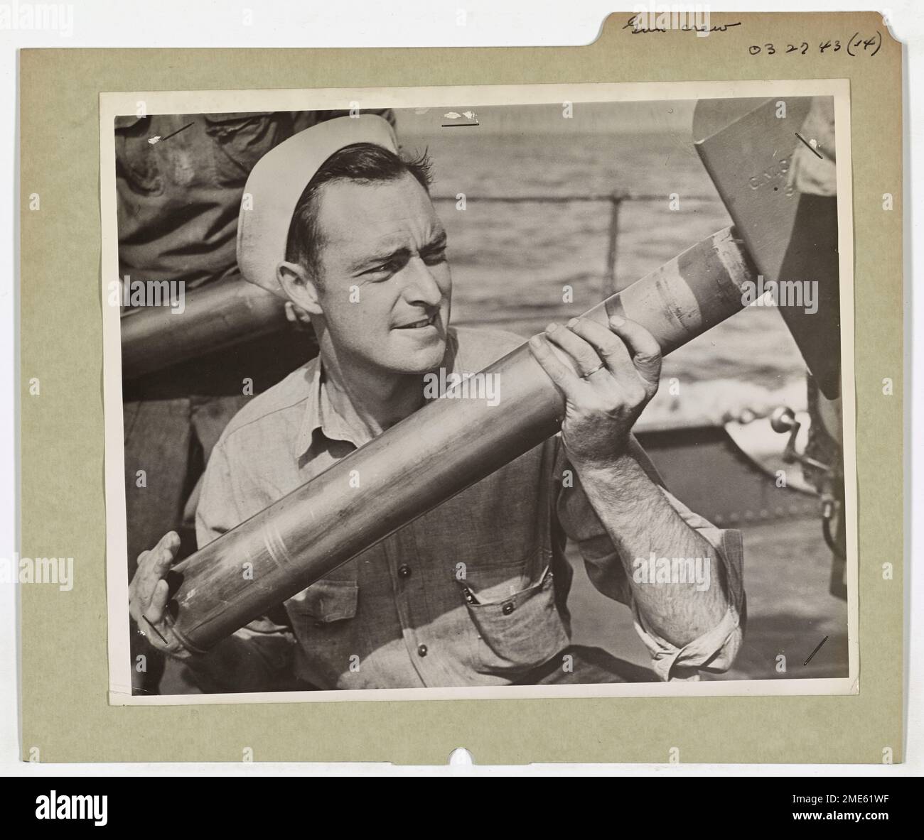 Ein Crew-Mitglied der Küstenwache rammt während einer Militäroperation eine Granate in die Öffnung einer montierten Kanone auf dem Deck eines Konvoi-Cutters der Küstenwache. Das Bild zeigt die Bereitschaft und wichtige Rolle der Küstenwache beim Schutz von Konvois während der Kriegszeit. Stockfoto