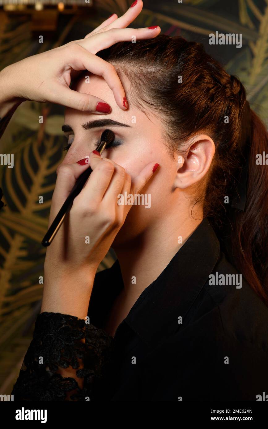 Professioneller Make-up-Künstler, der ein schönes Modell schminkt Stockfoto