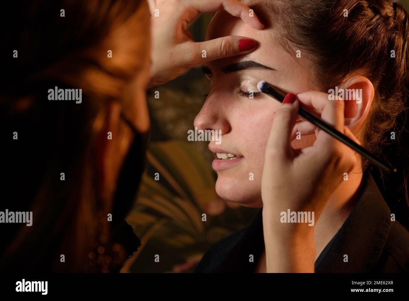 Professioneller Make-up-Künstler, der ein schönes Modell schminkt Stockfoto