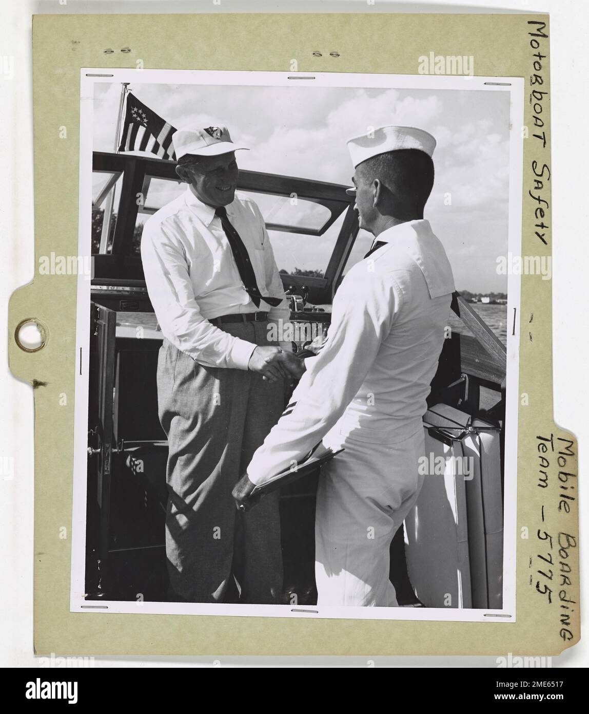 Mobiles Boarding-Team, Motorbootsicherheit. Washington, D.C., an Bord eines 30-Fuß- Hüttenkreuzer auf dem Potomac River Hier schüttelt John C. Gaskill, Boatswain's Mate 1., von einem mobilen Bordteam der Küstenwache, dem Besitzer die Hand und erklärt seine Mission. Gaskill prüft dann, ob die Sicherheitsanforderungen für dieses Motorboot der Klasse 2, 26ft, erfüllt sind. Auf weniger als 40 ft. In der Länge, werden vom Eigentümer ausgeführt. Stockfoto