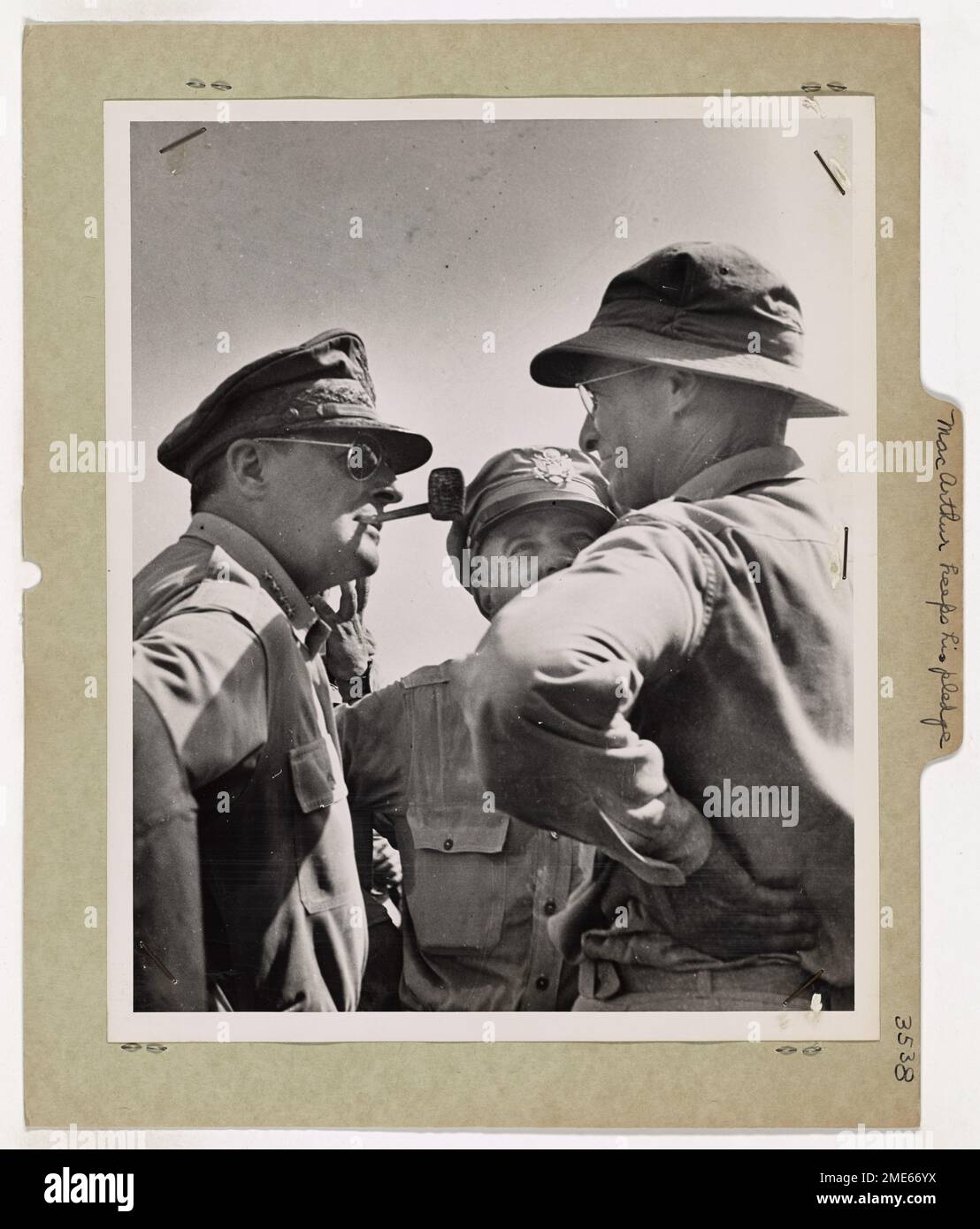 Dieses Bild zeigt General Douglas MacArthur, der ruhig eine Maiskolbenpfeife raucht, während er den Leyte Island Beachhead vermisst. Der Moment markiert die Erfüllung seines berühmten „I Shall Return“-Versprechens während des Zweiten Weltkriegs. Das Foto wurde von einem Kriegsfotografen der Küstenwache aufgenommen und zeigt die historische Bedeutung von MacArthurs Rückkehr auf die Philippinen. Stockfoto