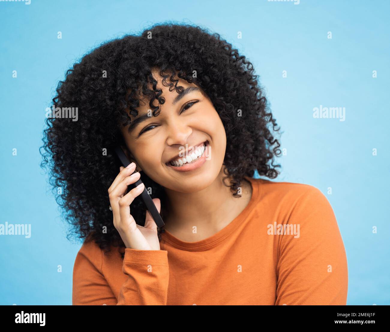 Afro-Porträt, schwarze Frau oder Anruf mit isoliertem blauem Hintergrund in lustigem Klatsch, Comedy-Nachrichten oder Comic-Story. Lächeln, Gesicht oder eine glückliche Person, die spricht Stockfoto