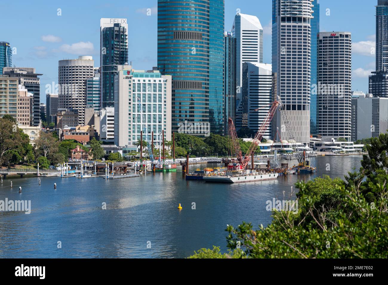 Brisbane, Australien – Januar 19 2023: Ponton mit großem Baukran am Brisbane River mit Stadtgebäuden im Hintergrund Stockfoto