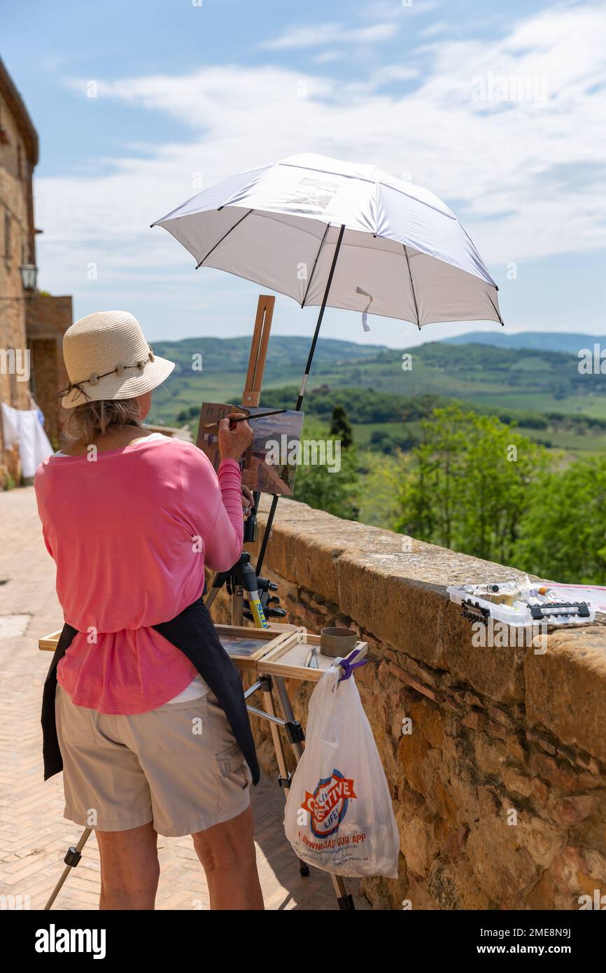 Künstlerin an einer Staffelei, die die toskanische Landschaft in Pienza, Toskana, Italien, malt. Stockfoto
