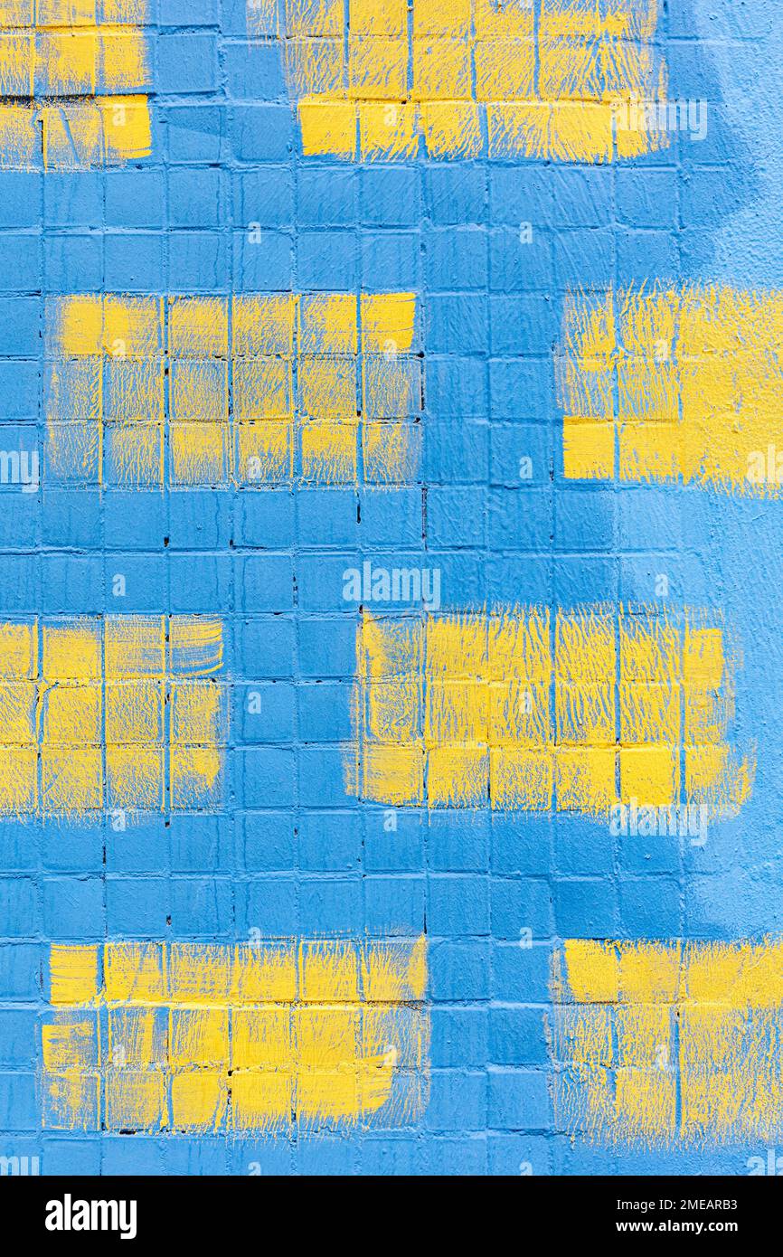 Striche gelber Malerwalze auf Fliesenwand blau gestrichen Stockfoto