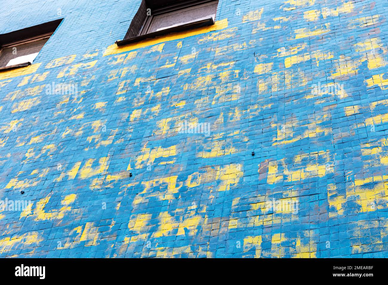 Blau bemalte Betonwand mit abstrakter, farbenfroher Straßenkunst Stockfoto