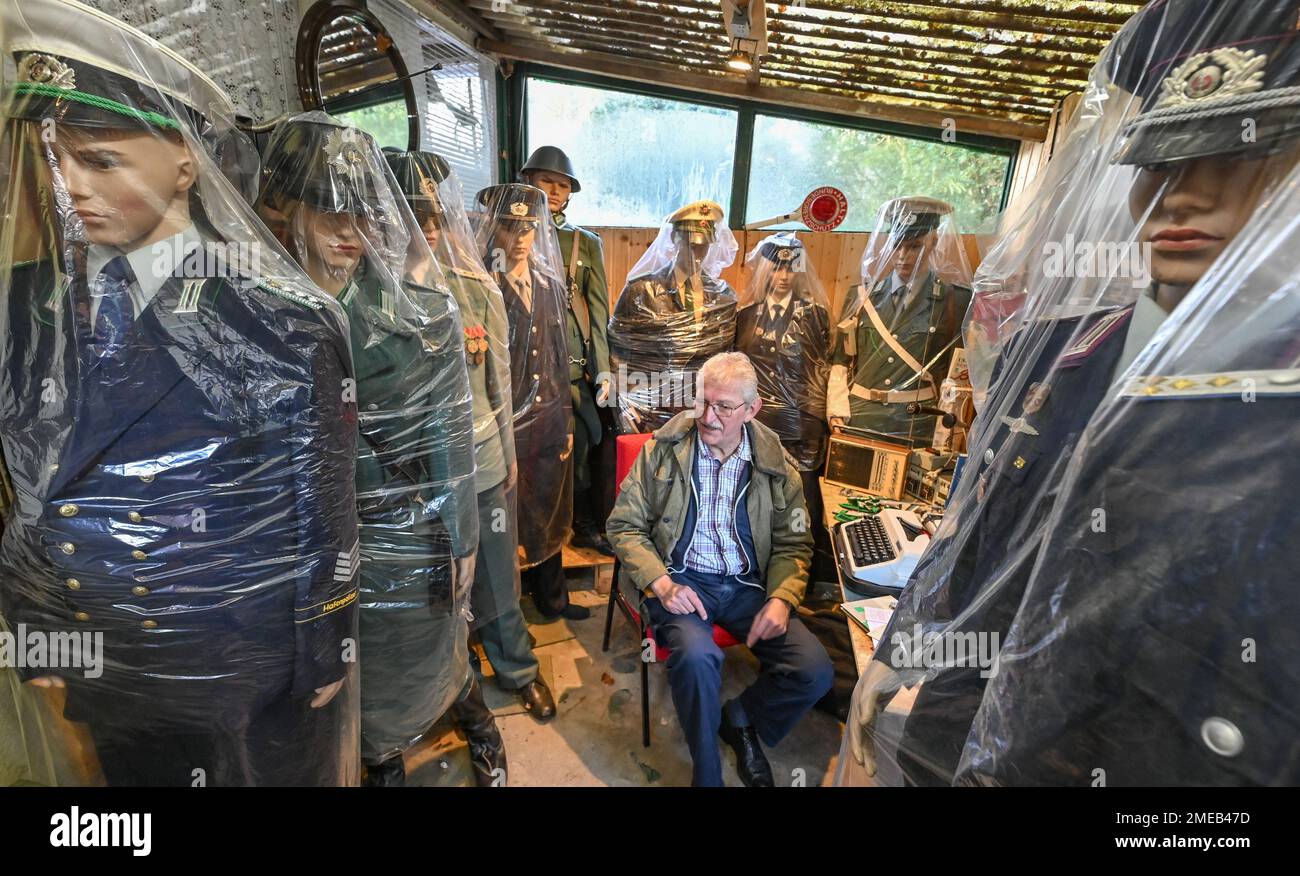 Eggersdorf, Deutschland. 19. Januar 2023. Christian Paul, Sammler, sitzt in seinem kleinen privaten Museum unter verschiedenen Figuren mit Uniformen, die in Plastiktüchern verpackt sind. Mit einer Polizei begann Lada vor etwa 15 Jahren, was sich jetzt zu einer umfangreichen Sammlung von Blaulicht entwickelt hat. Viele Uniformen und noch mehr alte Technologie, es gibt den Sammler Christian Paul zu bewundern. (Zu dpa-KORR „Täuschungsgeist – wenn Oldtimer der DDR renoviert werden“) Kredit: Patrick Pleul/dpa/Alamy Live News Stockfoto