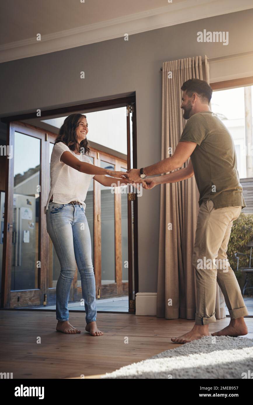 Romantik kommt in den zufälligsten Momenten. Ein glückliches junges Paar, das zu Hause tanzt. Stockfoto