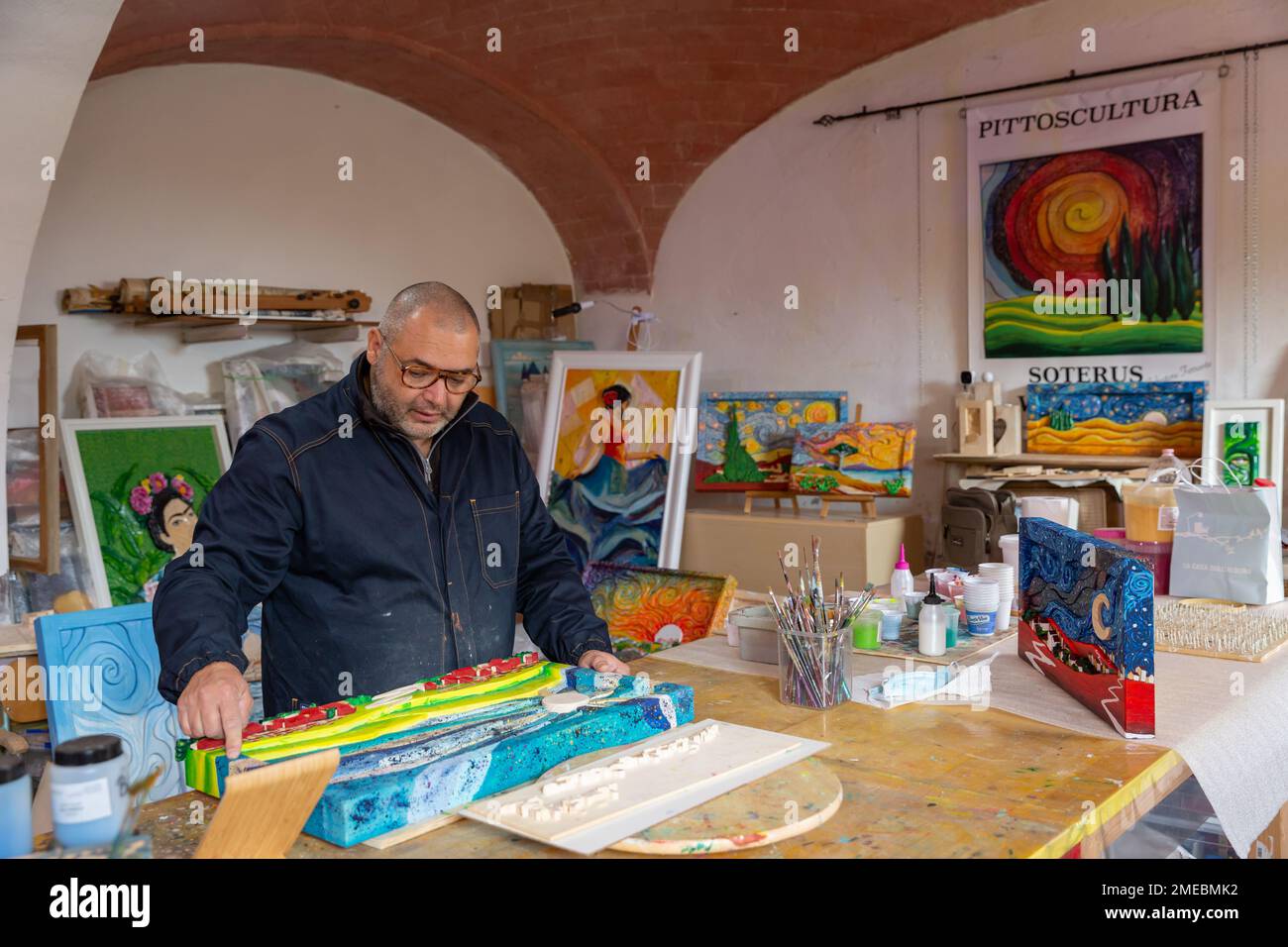 Der Handwerker/Künstler Salvatore Ferrante, „Soterus“, in seinem Atelier; bekannt für seine einzigartigen handgeschnitzten und handgemalten Holzbilder, Toskana, Italien. Stockfoto