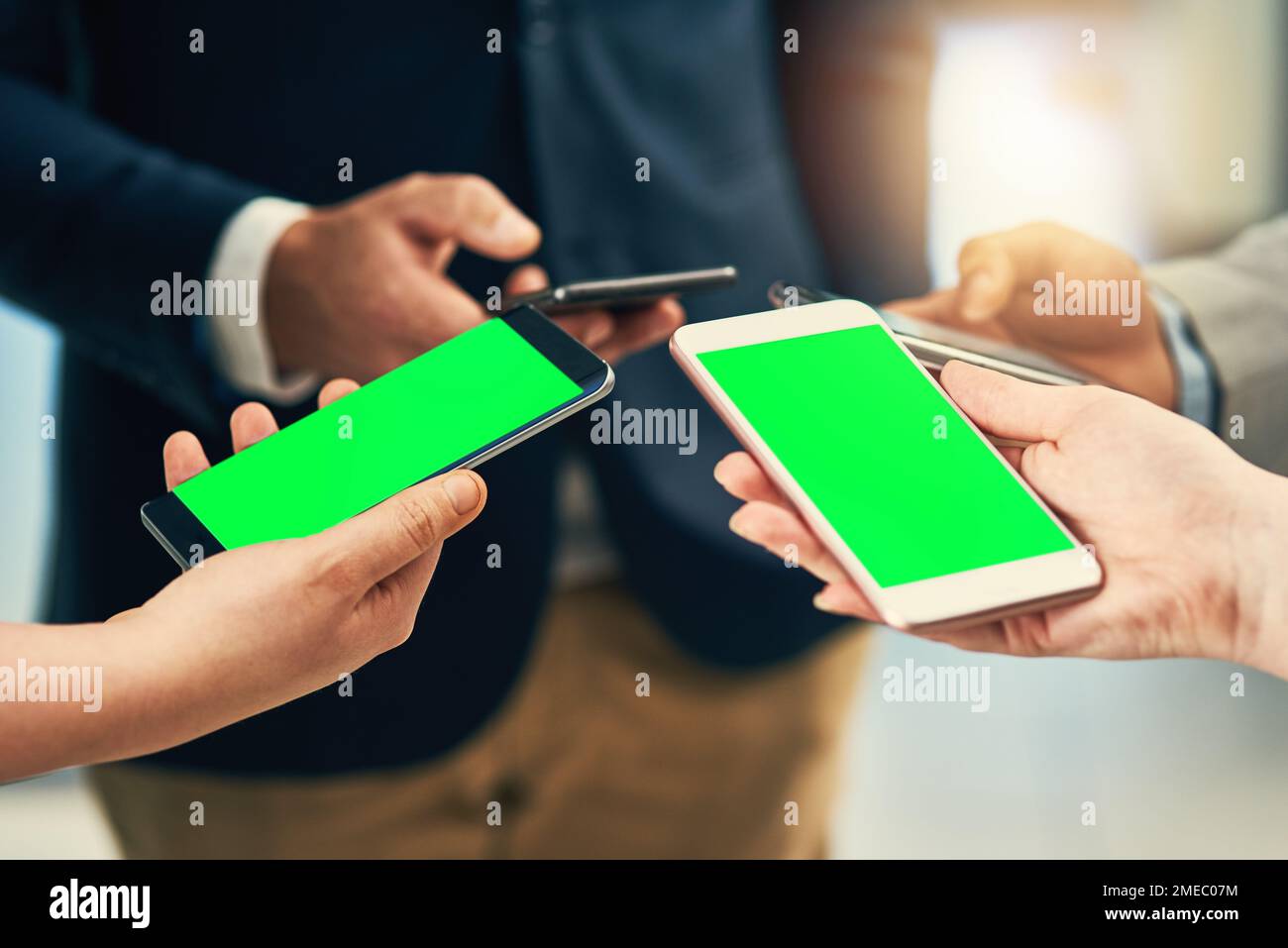 In einer mobilen Welt. Eine Gruppe von Geschäftsleuten, die während einer Zusammenarbeit ihre Mobiltelefone verwenden. Stockfoto