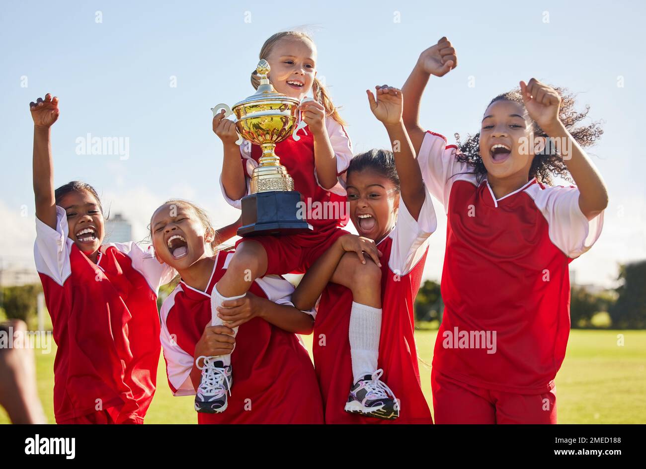 Fußball, Team und Trophäe mit Kindern, die gemeinsam als Siegergruppe für einen Sportwettbewerb feiern. Fußball, Teamwork und Auszeichnung mit Sport Stockfoto