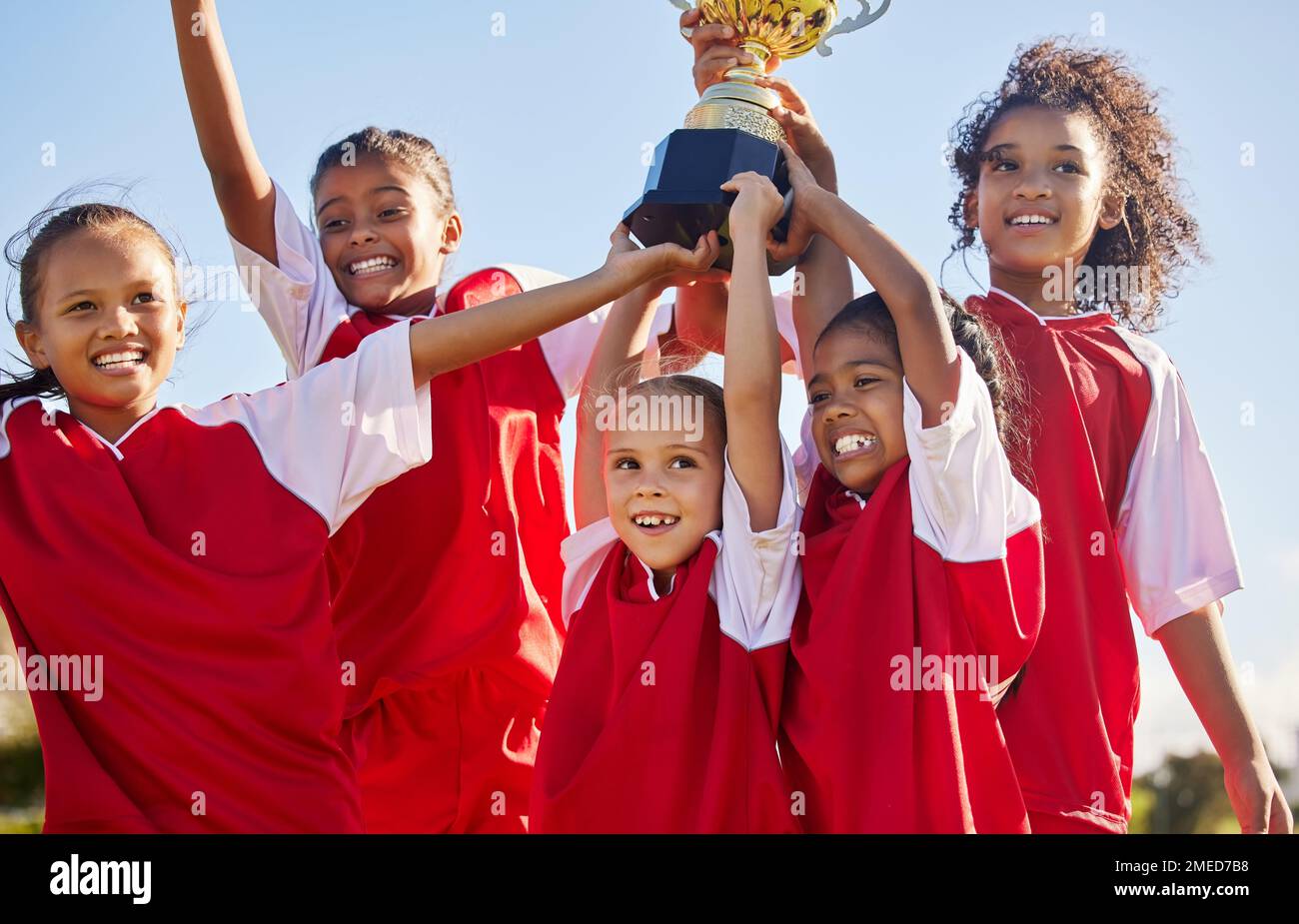 Fußball, Team und Trophäe mit Kindern, die gemeinsam als Siegergruppe für einen Sportwettbewerb feiern. Fußball, Teamwork und Auszeichnung mit Sport Stockfoto