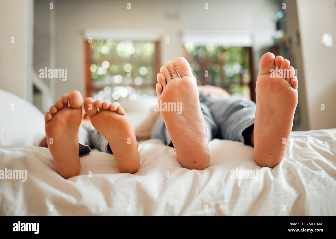 Füße, Familie und Vater schlafen auf einem Bett mit Kind in einem Schlafzimmer in einem Haus oder verbinden sich miteinander. Ruht euch aus, macht Pause und erzieht das Kind barfuß Stockfoto