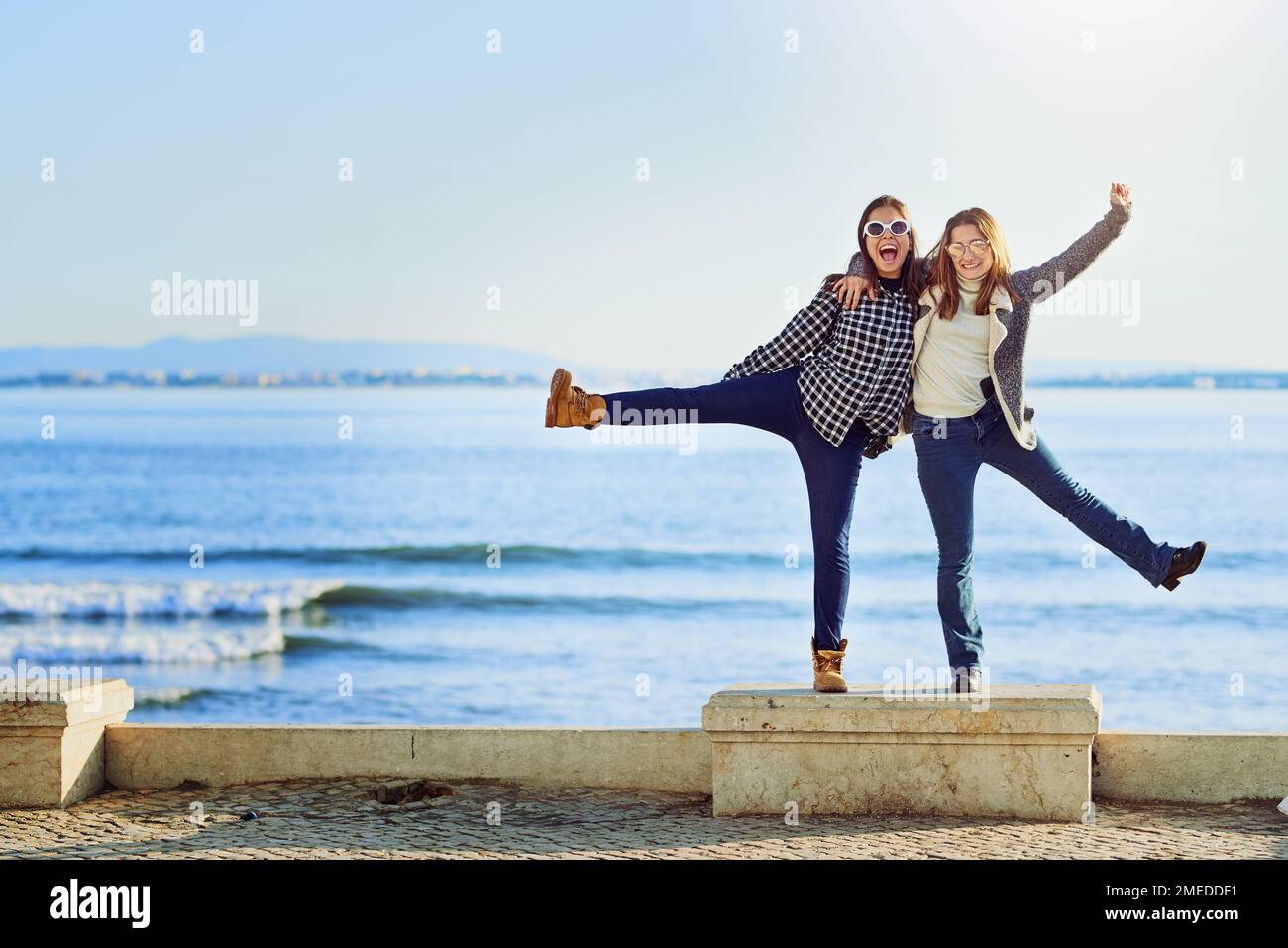 Loslassen. Ein langes Porträt von zwei attraktiven jungen Frauen, die einen Tag am Meer verbringen. Stockfoto
